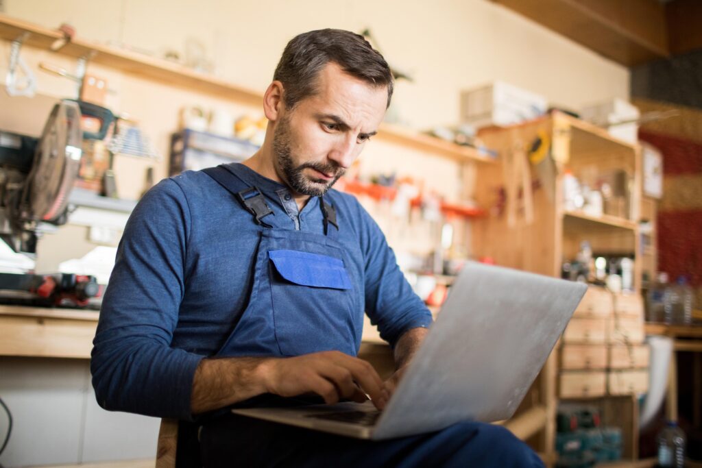 man working on laptop in workshop