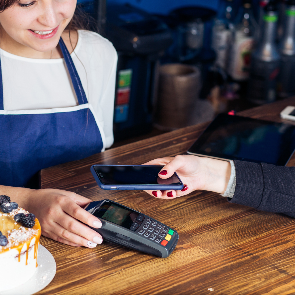 hands using phone to pay at coffee shop