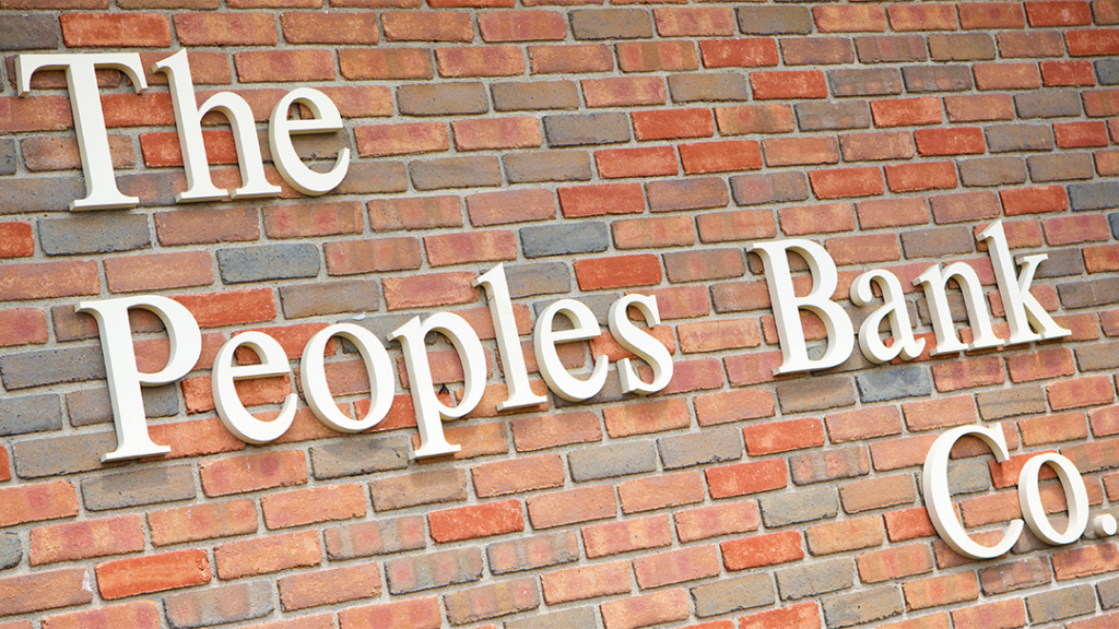 The Peoples Bank Co. logo on brick wall